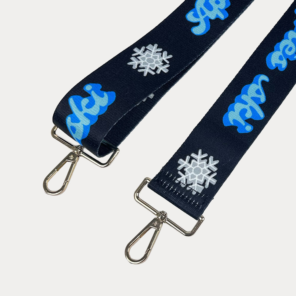 Black ground with Apres Ski text in Blue and white snowflakes printed bag strap with gold hardware