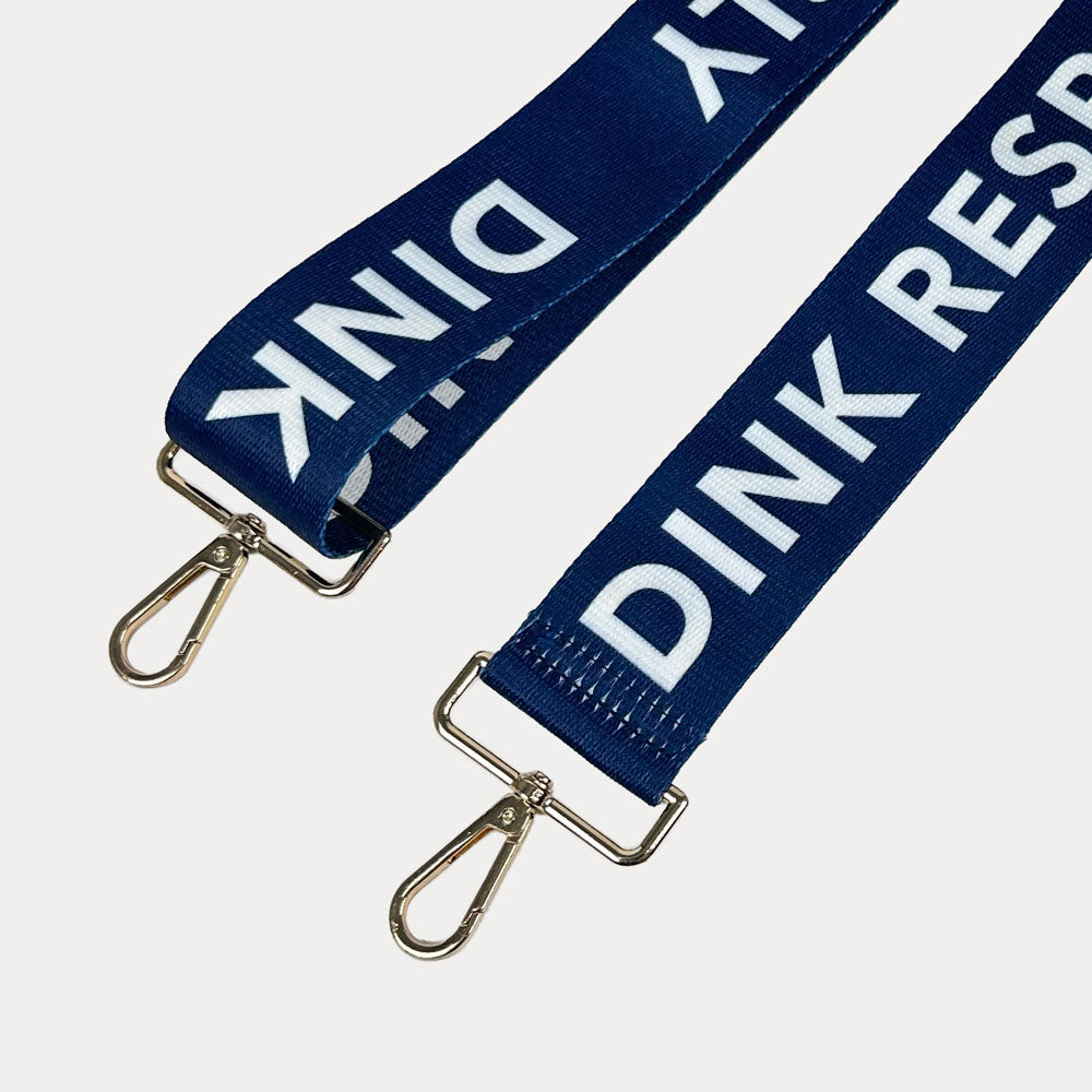 Navy ground with Dink Responsibly text with gold hardware bag strap