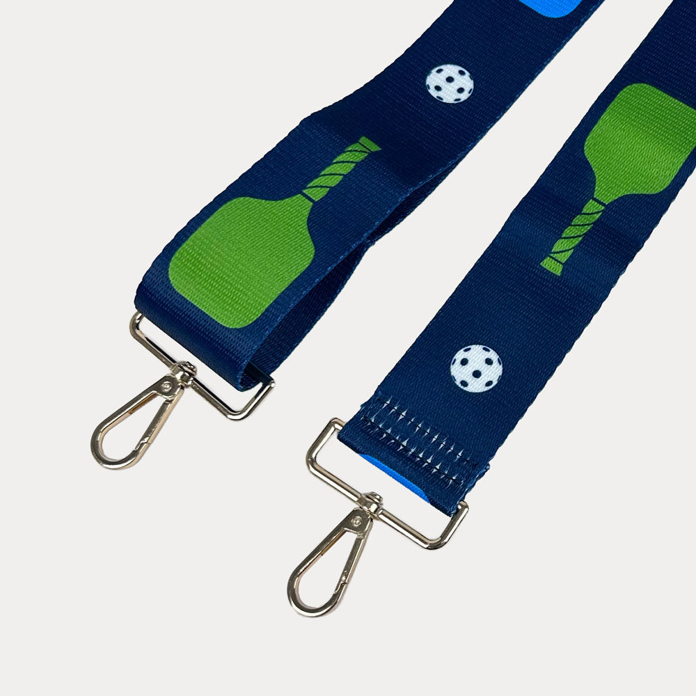 Navy ground with colorful pickleball paddles and white pickleball graphics with gold hardware bag strap