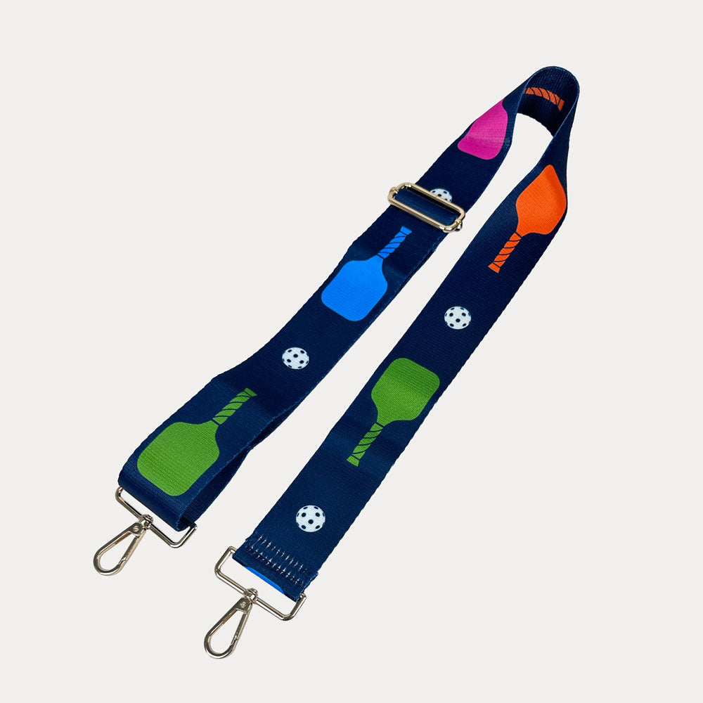 Navy ground with colorful pickleball paddles and white pickleball graphics with gold hardware bag strap