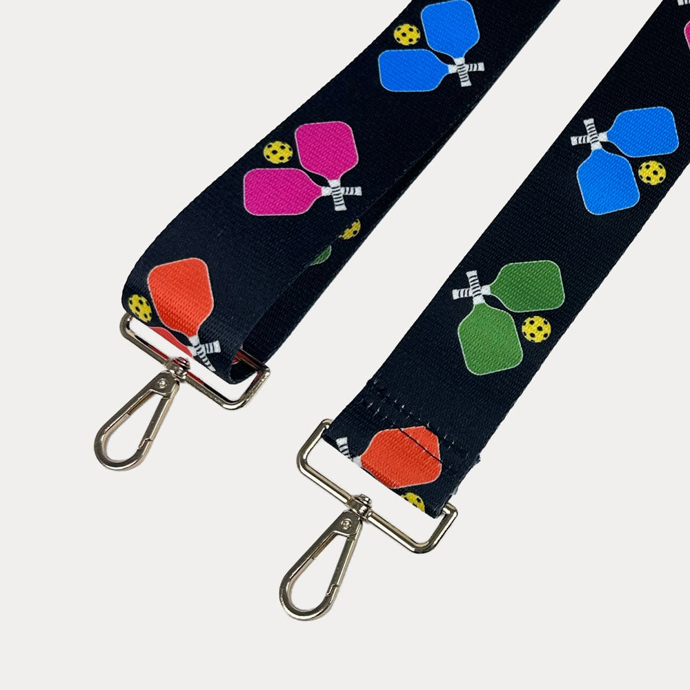 Black ground with colorful pickleball paddle graphics with gold hardware bag strap