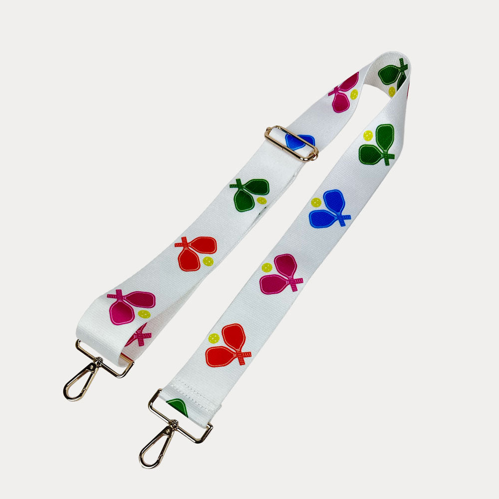 White ground with colorful pickleball paddle graphics with gold hardware bag strap