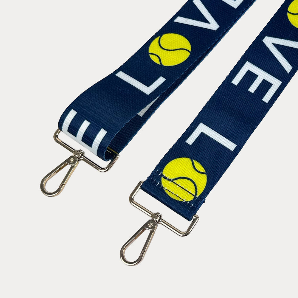 Navy ground with 'LOVE' text and tennis ball graphics with gold hardware bag strap