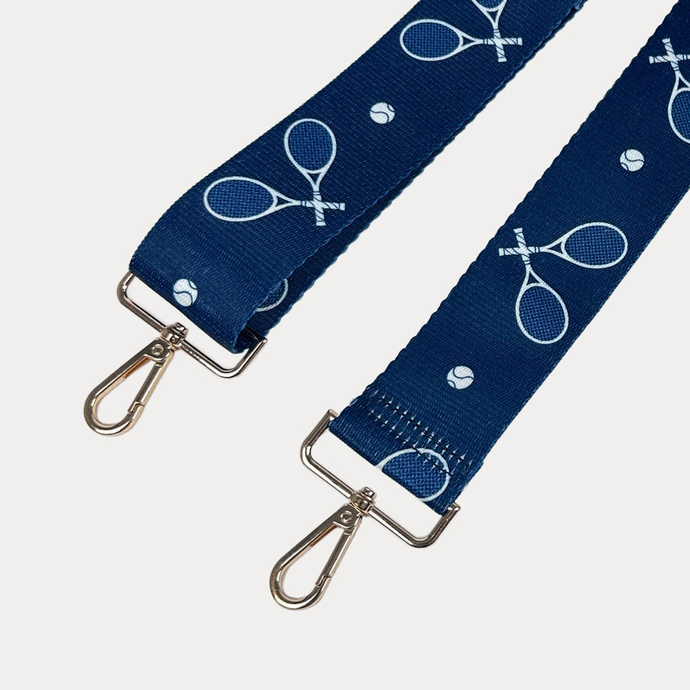 Navy ground with tennis racket graphics with gold hardware bag strap