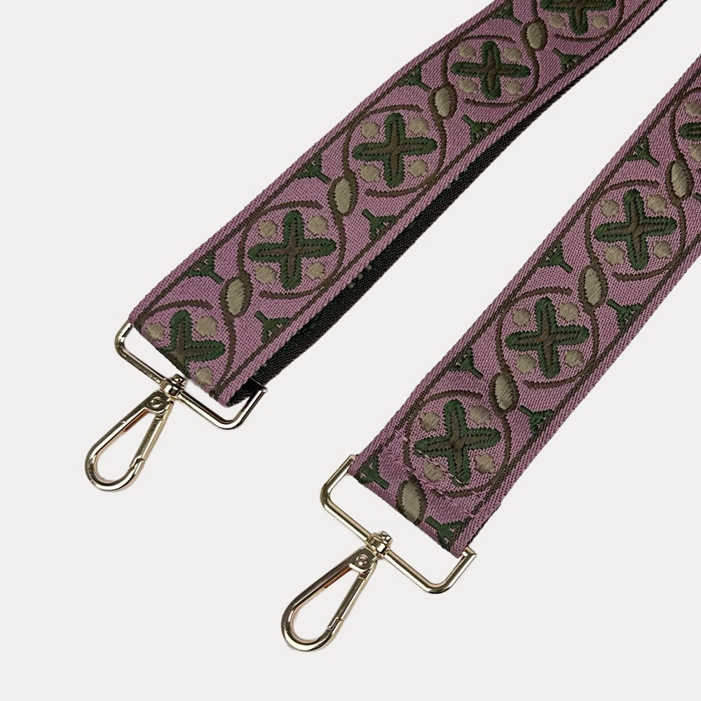 XO Patterned bag strap with gold hardware on a light gray background