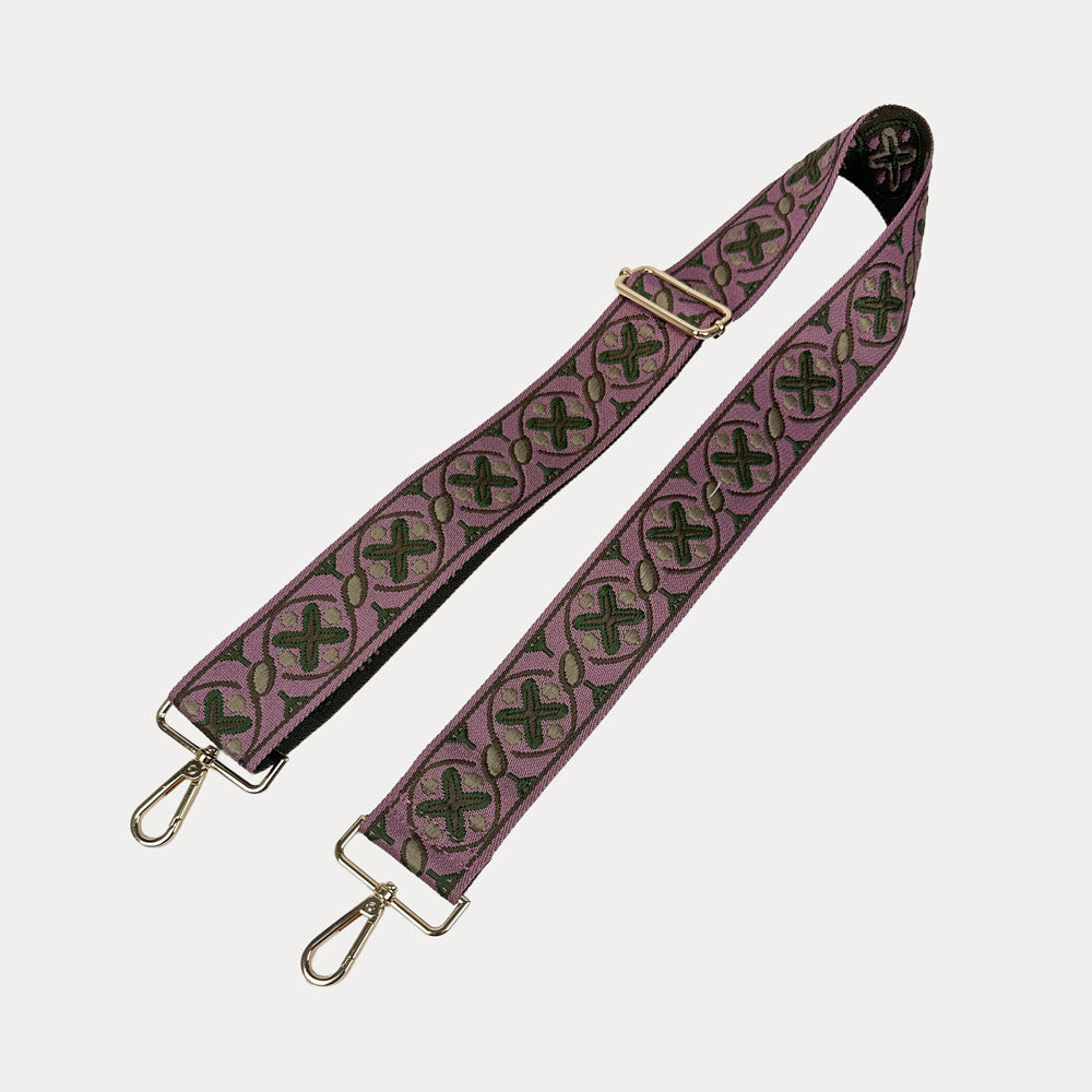 XO Patterned bag strap with gold hardware on a light gray background