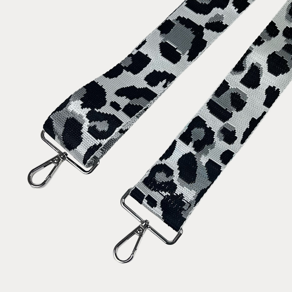 Leopard print strap with silver metal clasps on a white background