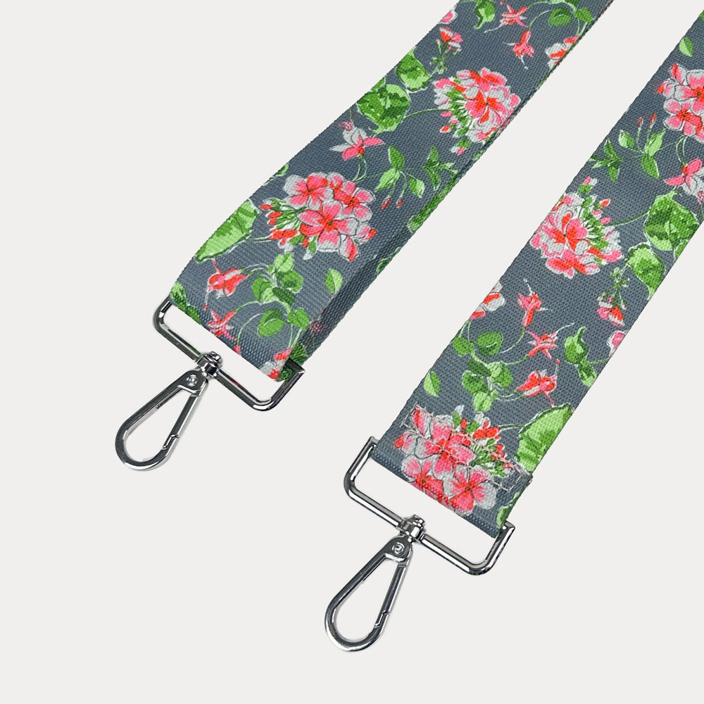 Grey ground floral patterned strap with silver hardware on a light gray background
