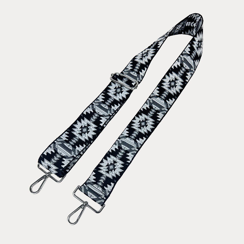 Black and white patterned strap with sliver hardware on a light gray background