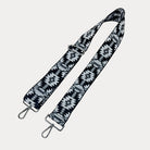 Black and white patterned strap with sliver hardware on a light gray background