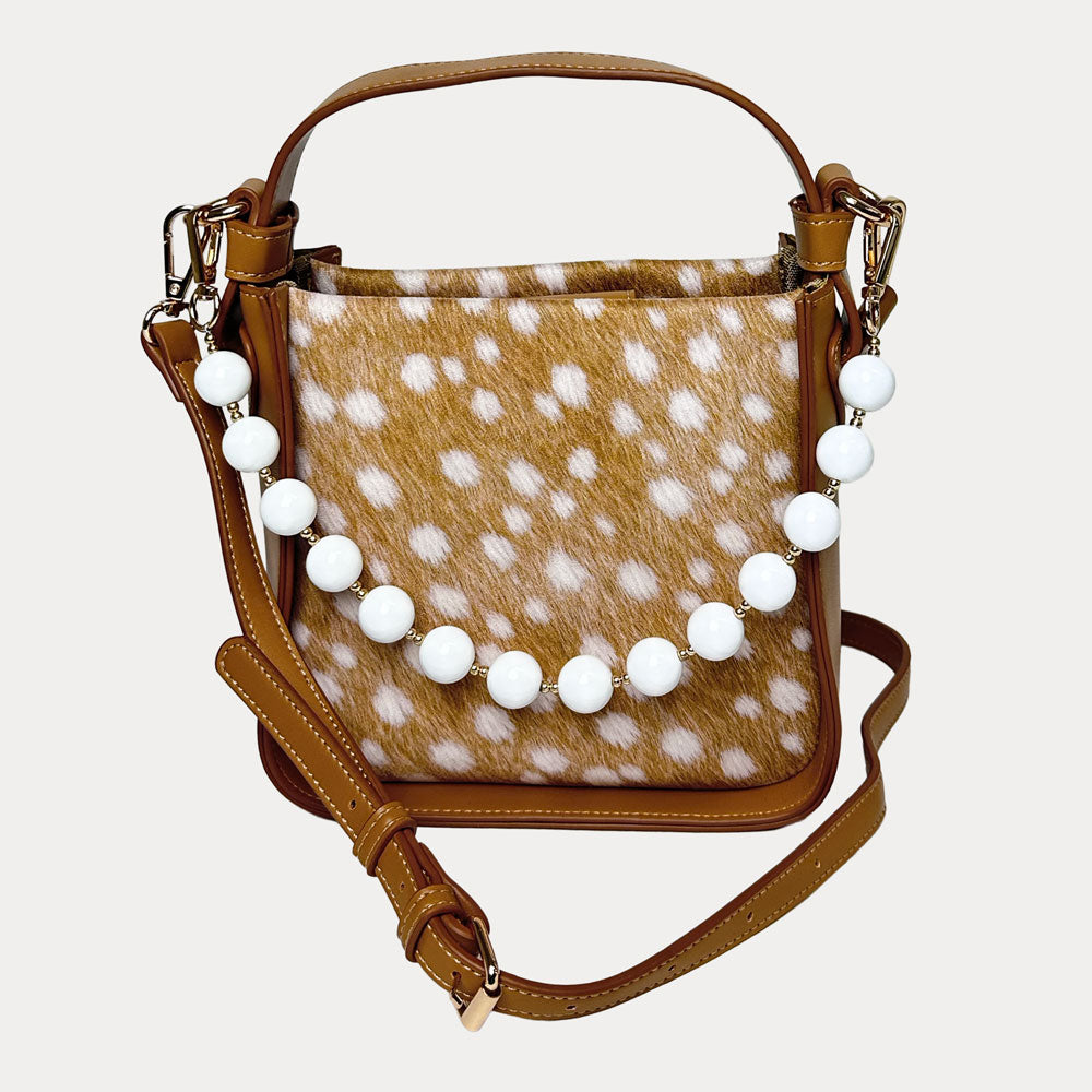Handbag with deer pattern vegan suede and camel vegan leather details on a beige background