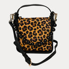 Handbag with leopard pattern vegan suede and black vegan leather details on a beige background