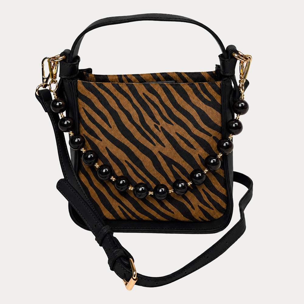 Handbag with zebra pattern vegan suede and black vegan leather details on a beige background