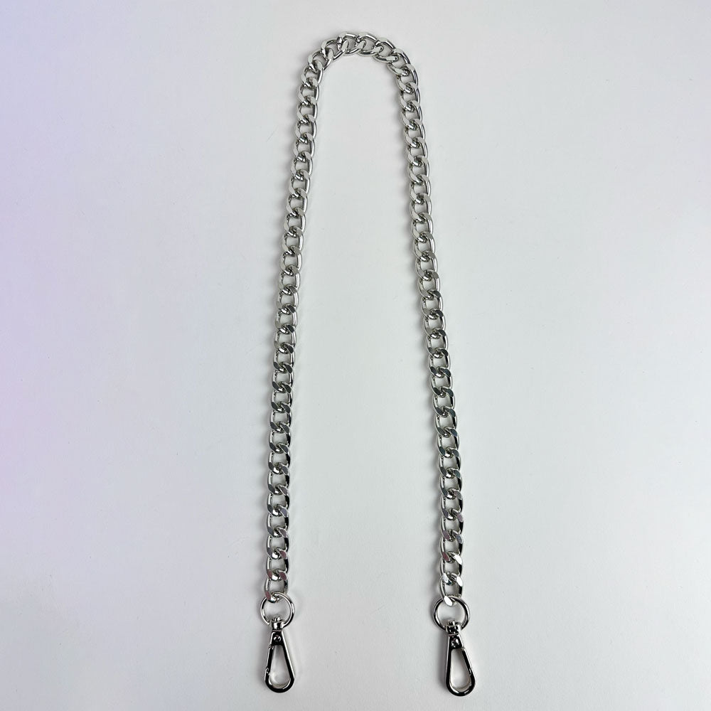 Silver metal chain bag strap on a light grey background