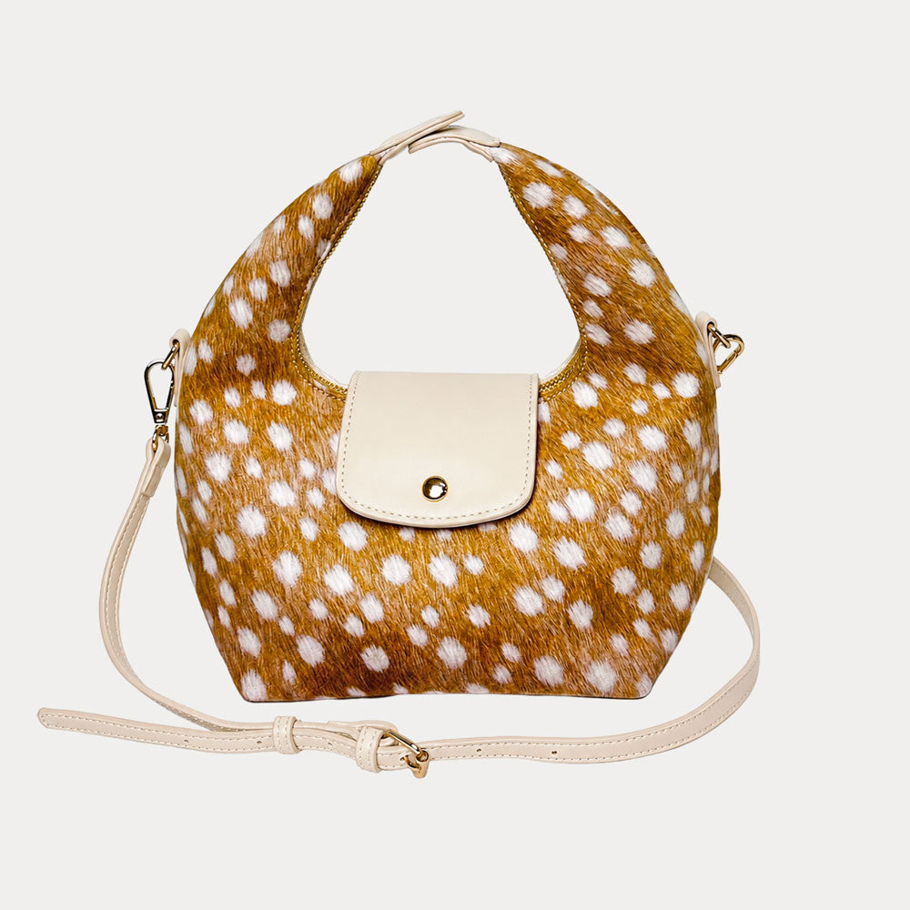 Handbag with deer print vegan suede and cream leather accents on a light gray background