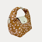 Handbag with deer print and cream leather accents on a light gray background- Side View