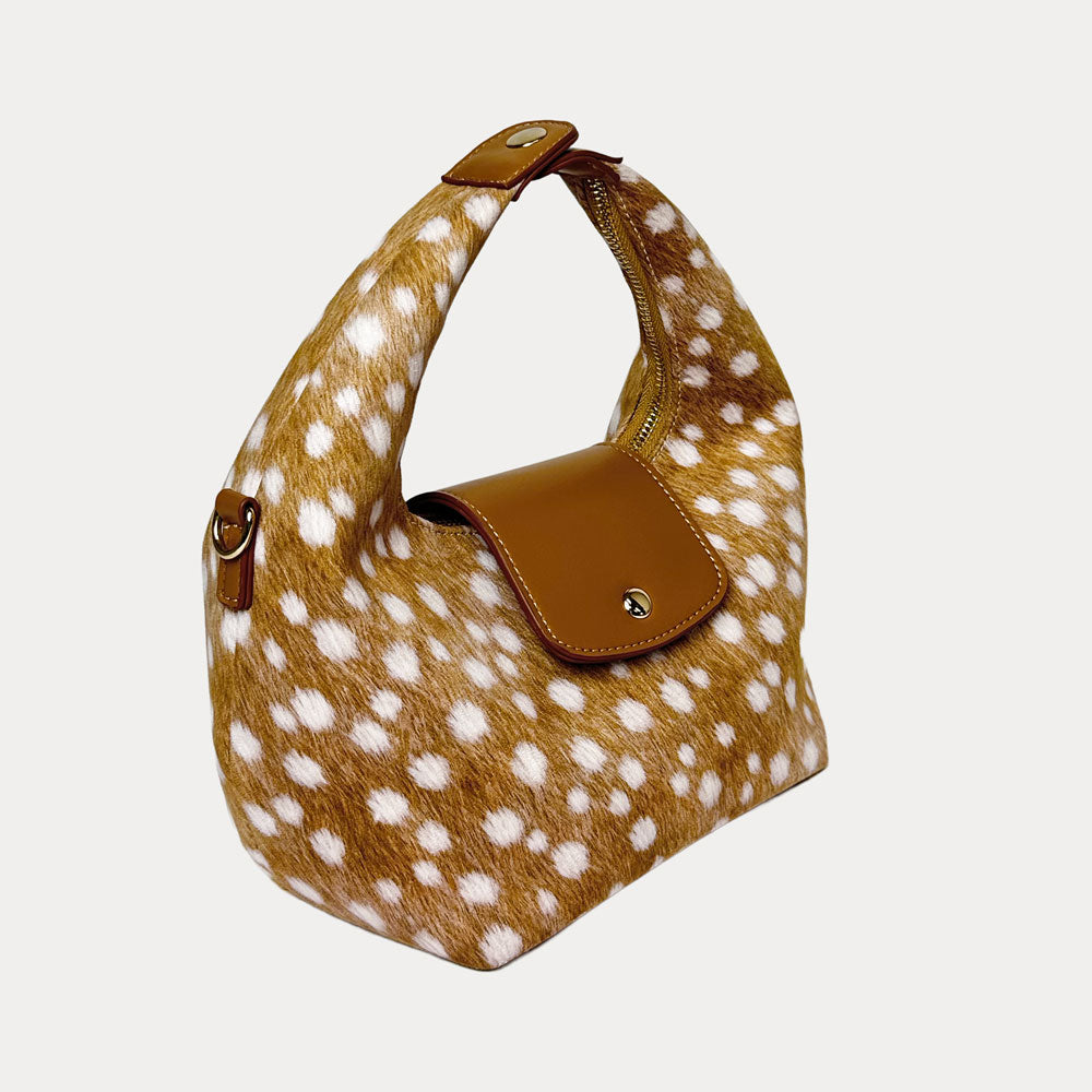 Handbag with deer print and camel leather accents on a light gray background- Side View