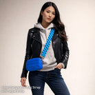Woman wearing a black leather jacket, gray hoodie, and blue jeans with a blue crossbody bag on a beige background