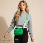 Woman wearing a green puffer bag with a houndstooth strap on a beige background