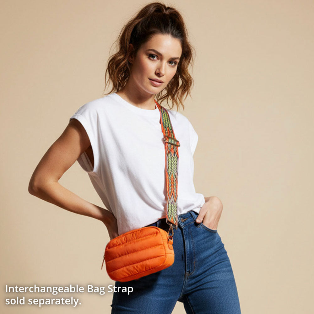 Woman wearing an orange puffer bag with a beige background