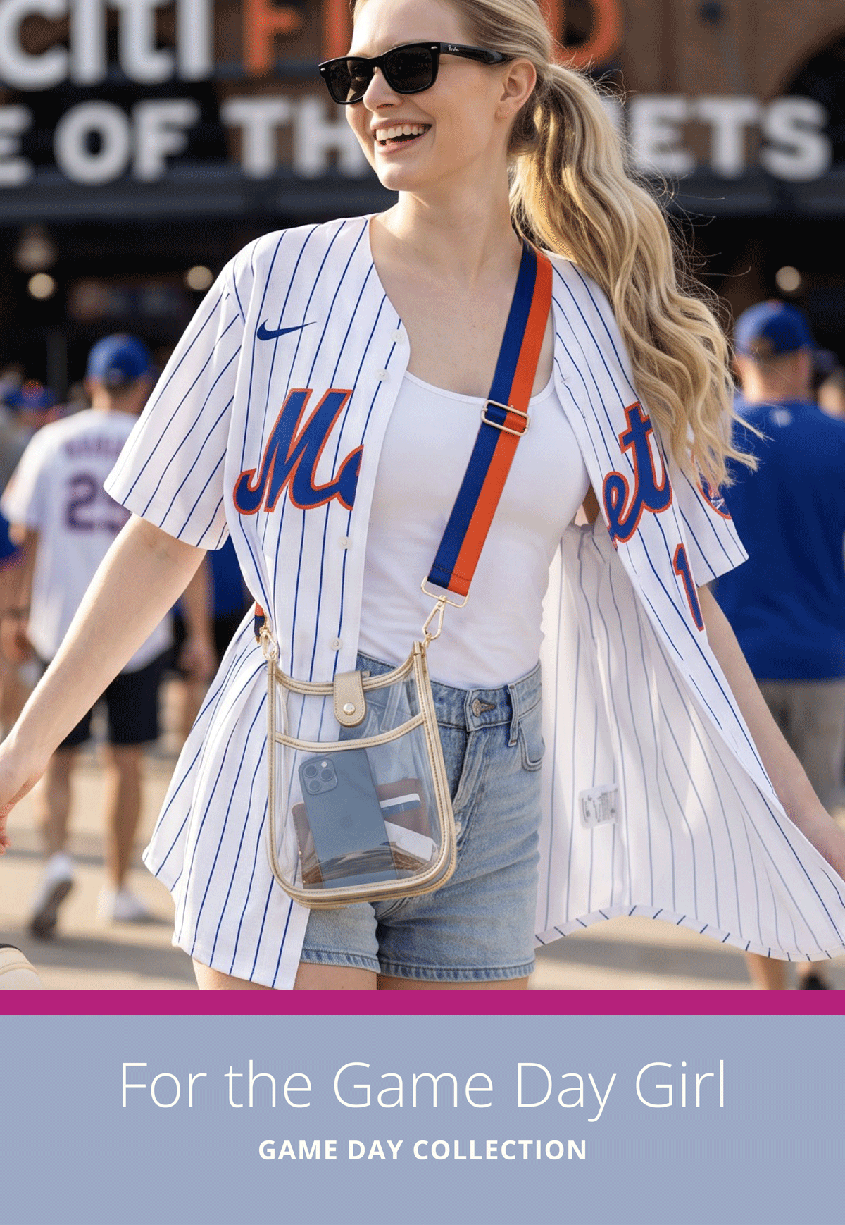 For the Game Day Girl. Game Day Collection. Woman outside a baseball stadium, wearing a clear game day bag and game day bag strap. 
