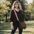 Woman in a brown sweater with a brown bag in a park