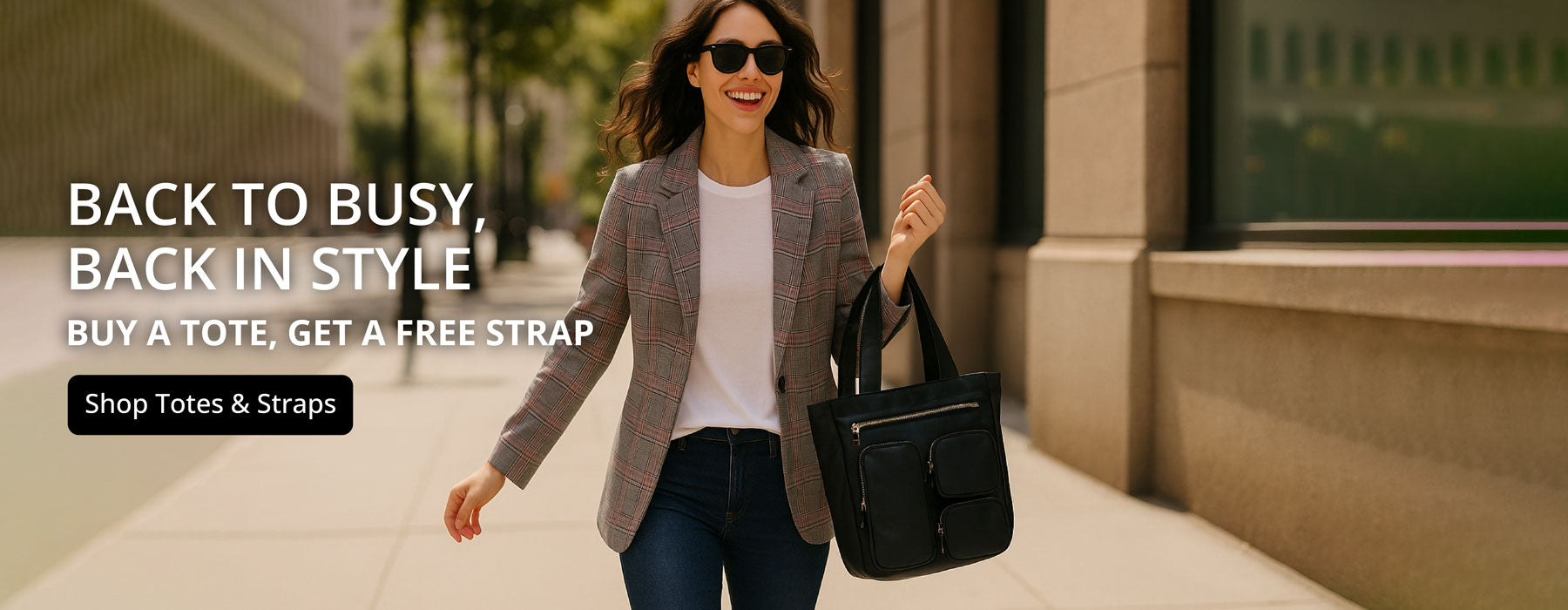 Woman walking with a black tote bag on a sidewalk, promotional text overlay- Back to Busy, Back in Style. Button: Shop Totes & Straps