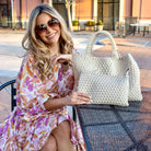 Woman holding a woven neoprene tote outdoors