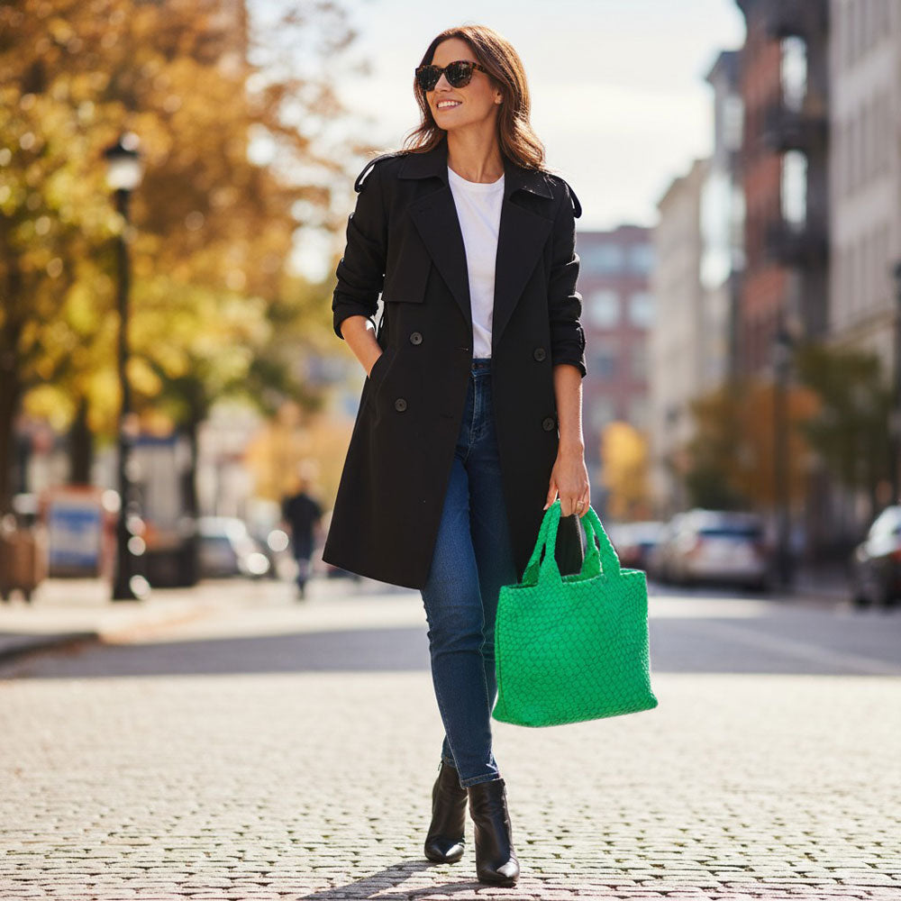 Woman walking on a city street holding a neon green tote