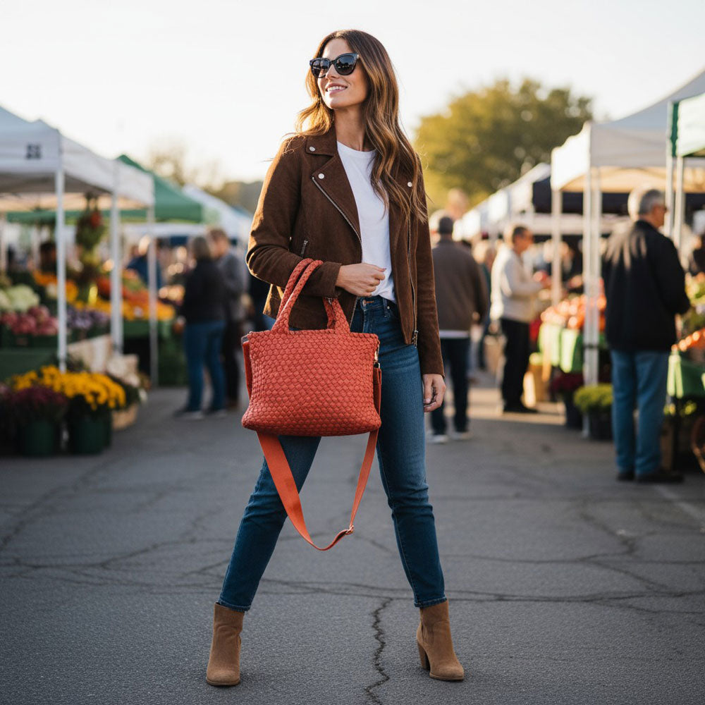 Woman with a pumpkin orange tote at an outdoor market