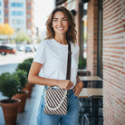 Woman holding a patterned bag outdoors near a brick building