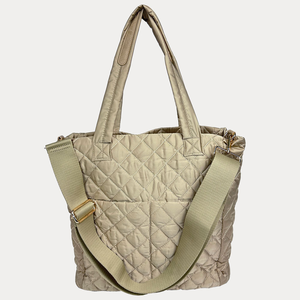Quilted beige handbag with a shoulder strap on a light gray background