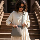 Woman holding a dune handbag on a staircase