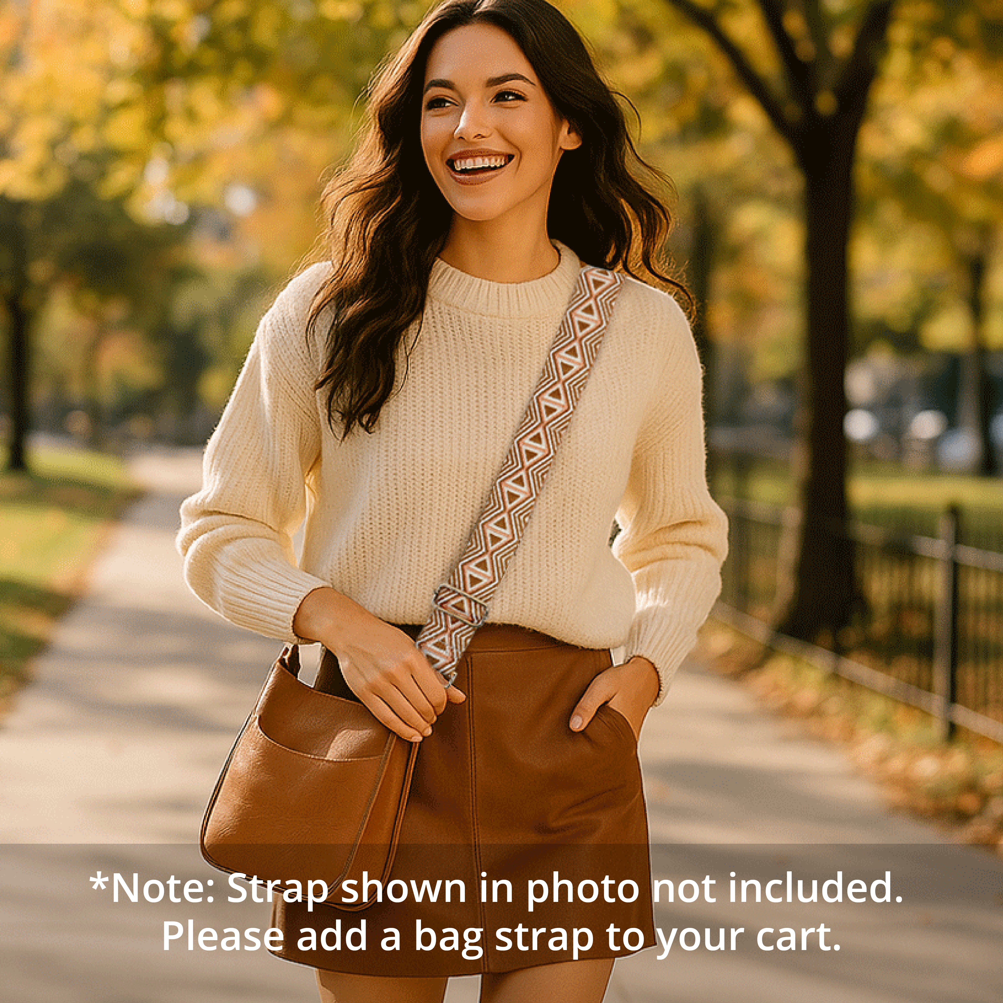 woman walking in the park, wearing a camel messenger bag with a printed bag strap across her body