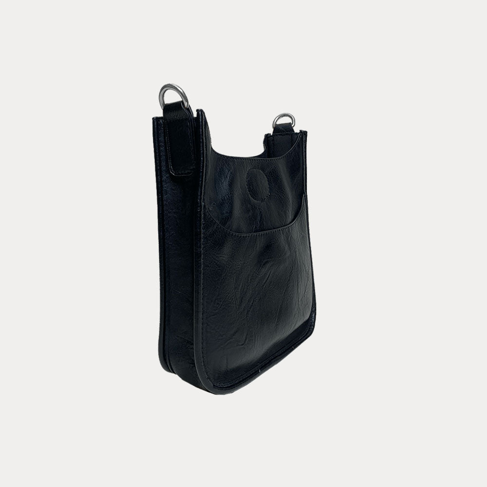 Side view of the Mini Vegan Leather Messenger in Black with Silver Hardware on grey background
