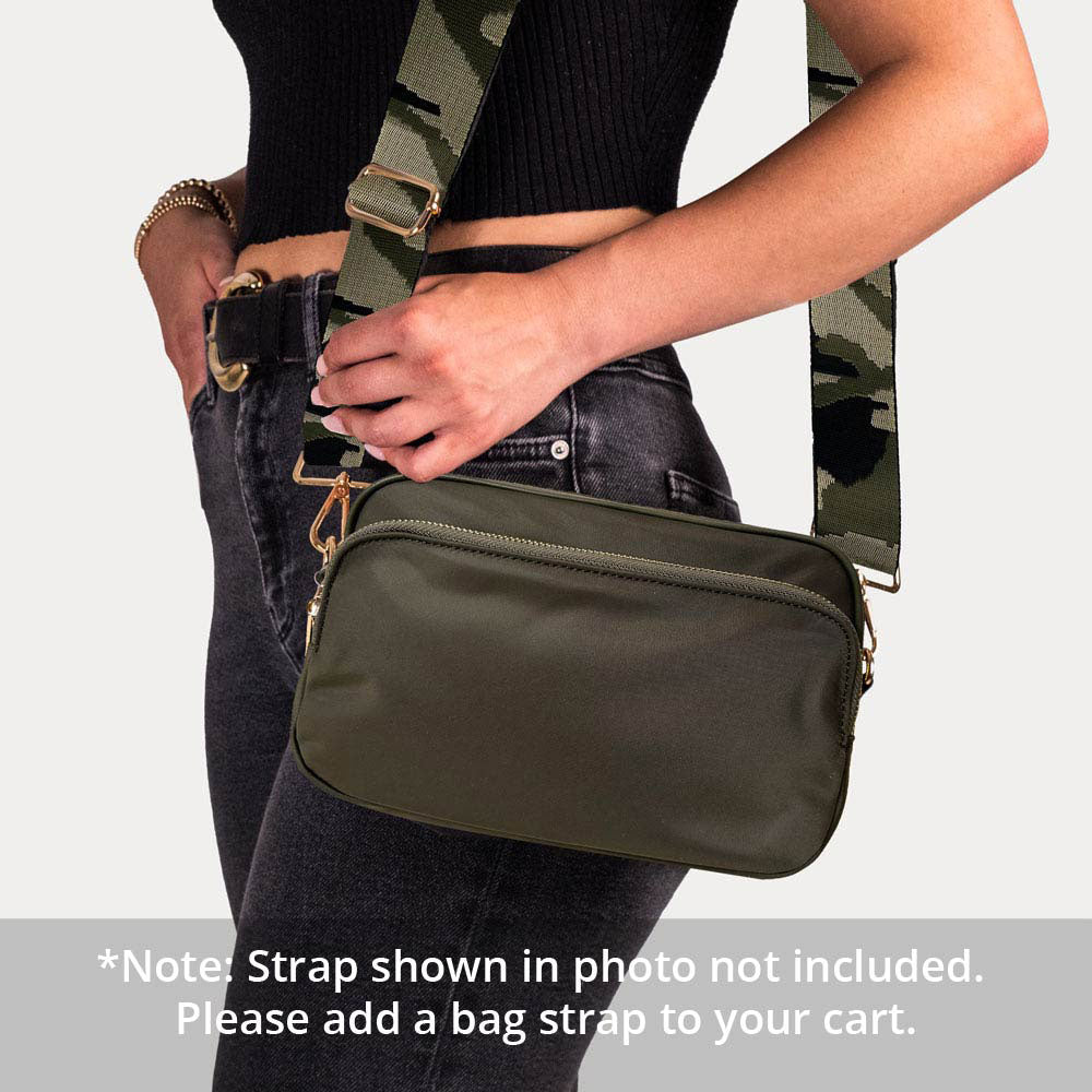 Person wearing a green crossbody bag with a camouflage strap on a light gray background. Text: Note: Strap Shown in photo not included.  Please add a bag strap to your cart.