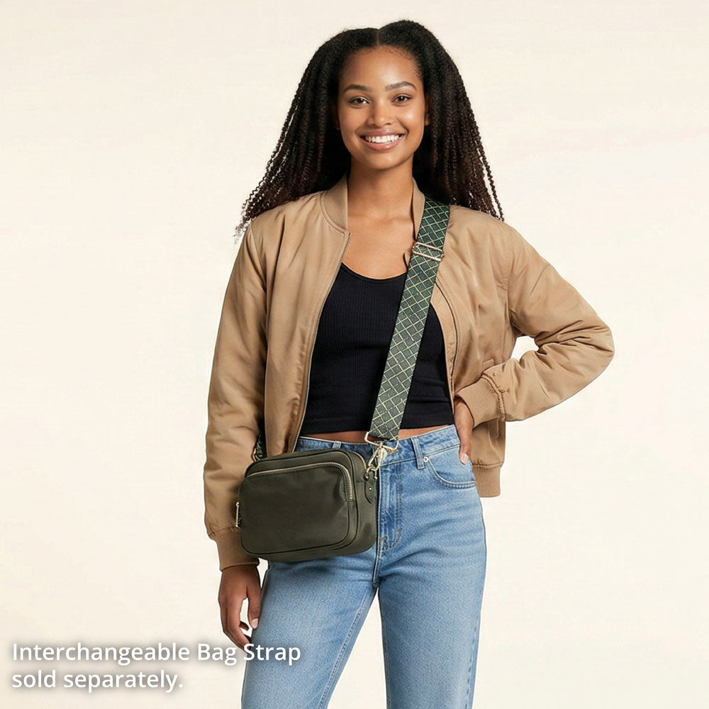 Woman wearing a army crossbody bag with an interchangeable strap on a beige background