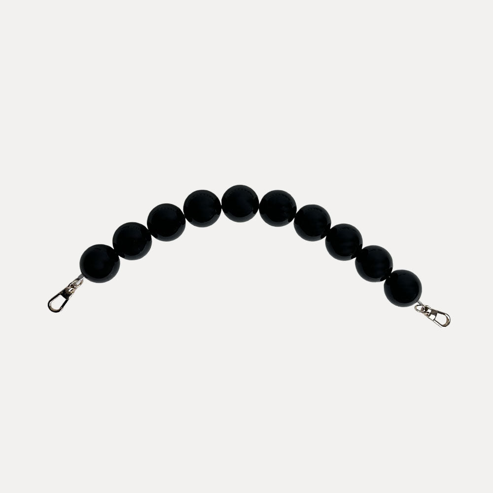 A black colored resin bead bag strap.
