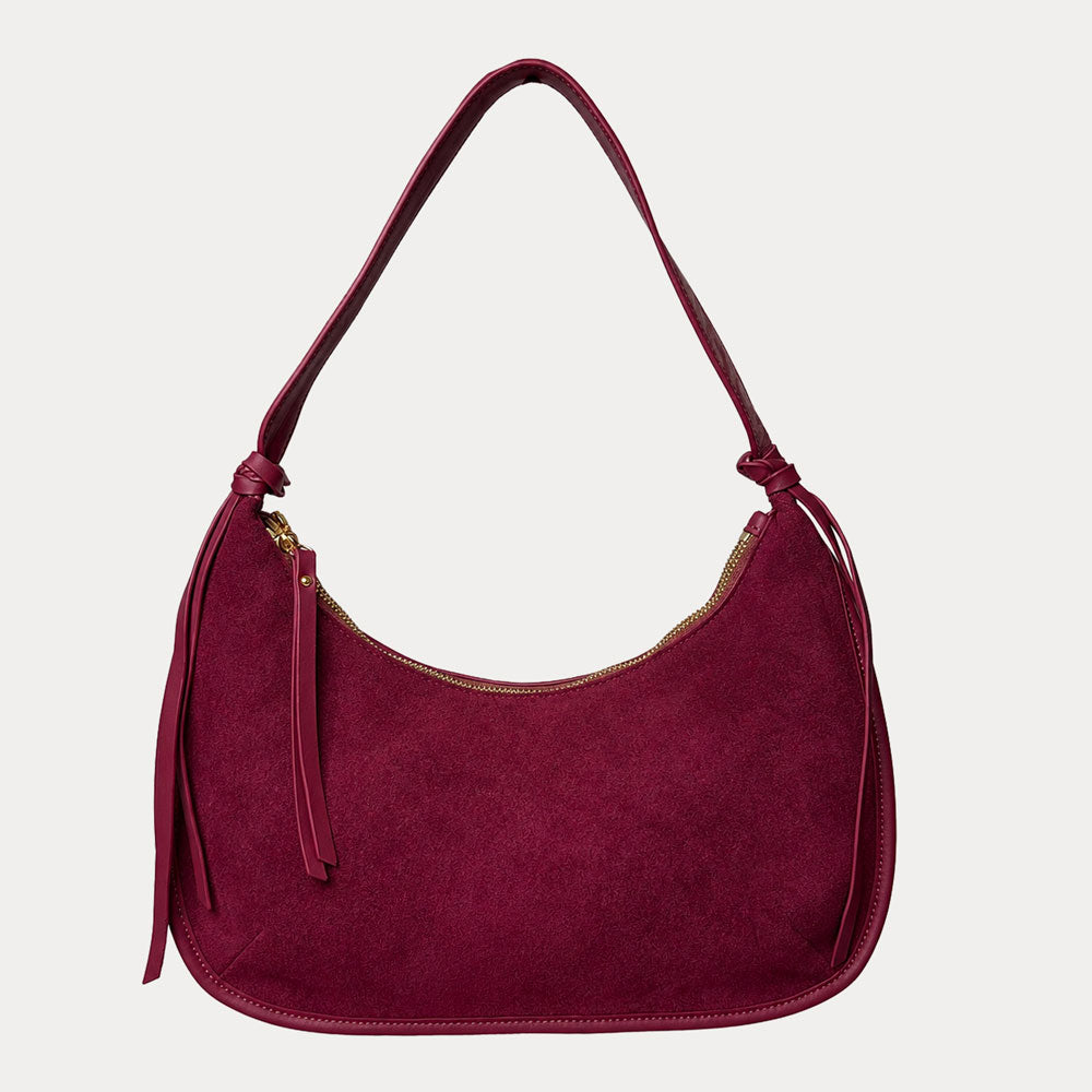 Burgundy vegan suede handbag on a light gray background