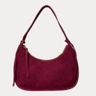 Burgundy vegan suede handbag on a light gray background