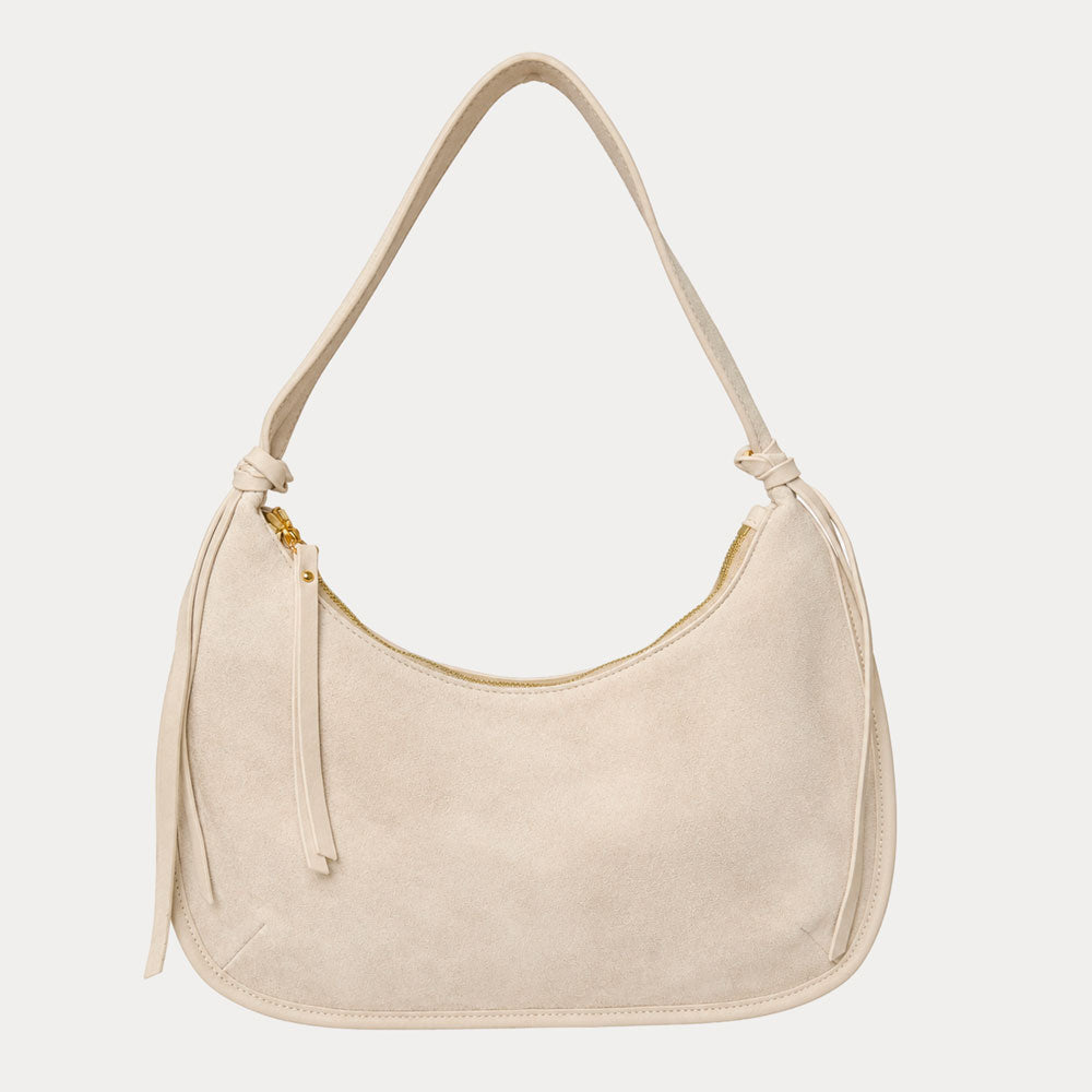 Cream vegan suede handbag on a light gray background