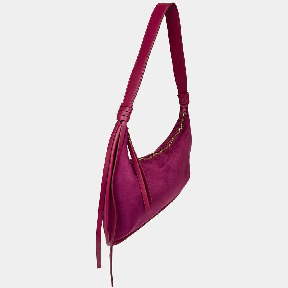 A burgundy vegan suede shoulder bag with vegan leather strap and tassel detail, shown from a side profile view against a light gray background.