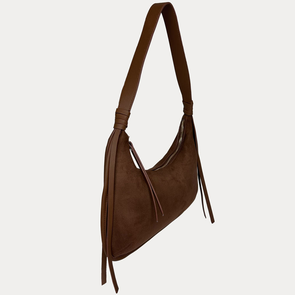 A chocolate vegan suede shoulder bag with a vegan leather strap and hanging fringe details, shown against a light gray background.