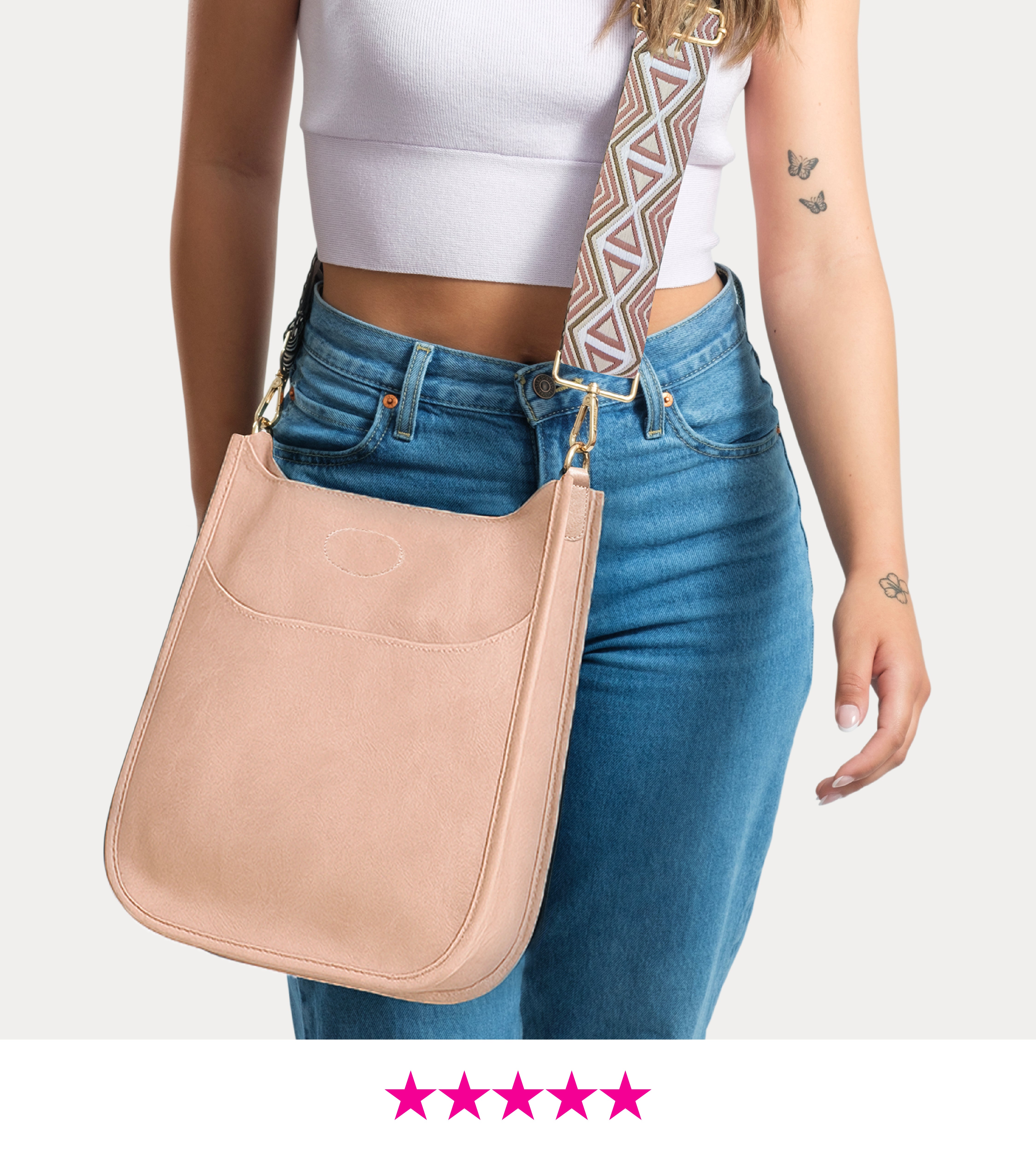 blush classic messenger bag worn by a person with a white top and blue jeans on a light gray background.